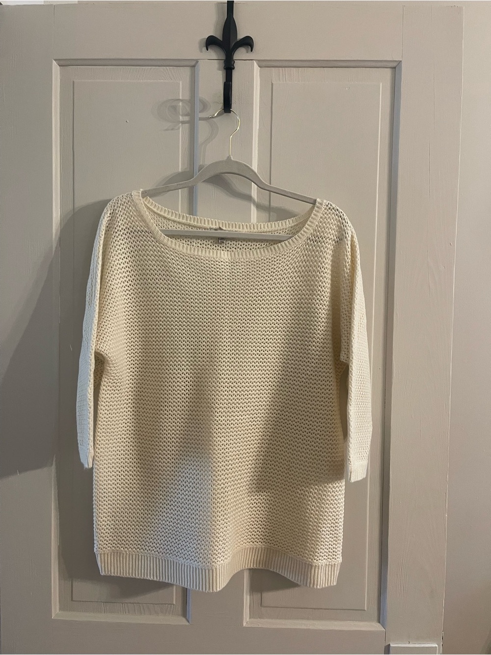 Boutique sweater sits on edge of shoulders